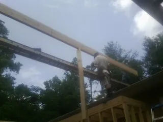 Carpenter setting a ridge beam over a new addition frame — Ice Dam Removal by Roofing Brothers in Waconia