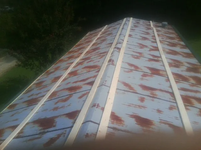 Rusted metal roof panels with new wood purlins before replacement — Storm Damage Roof Repair in Waconia by Roofing Brothers